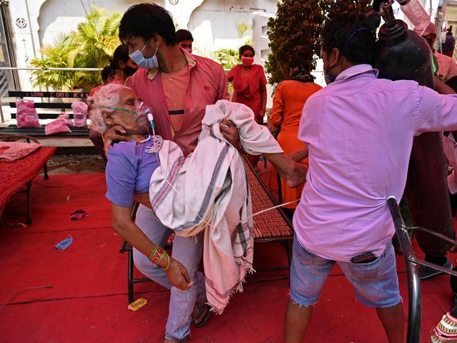 A family member carries a patient breathing with the help of oxygen in Ghaziabad, India. Picture: Tauseef Mustafa / AFP)