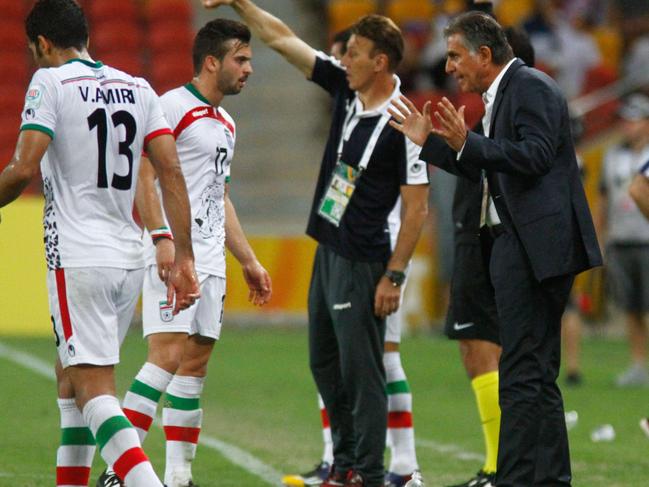 Carlos Queiroz (R), coach of Iran, speaks to player Soroush Rafiei (2nd L) during their Group C football match against the United Arab Emirates at the AFC Asian Cup in Brisbane on January 19, 2015. AFP PHOTO / John PRYKE --- IMAGE RESTRICTED TO EDITORIAL USE - STRICTLY NO COMMERICAL USE --