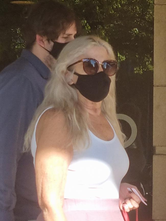 Nathan Fenwick appears to hide behind his mother after leaving court for preying on a student at a school. Photo: Lucy Rutherford