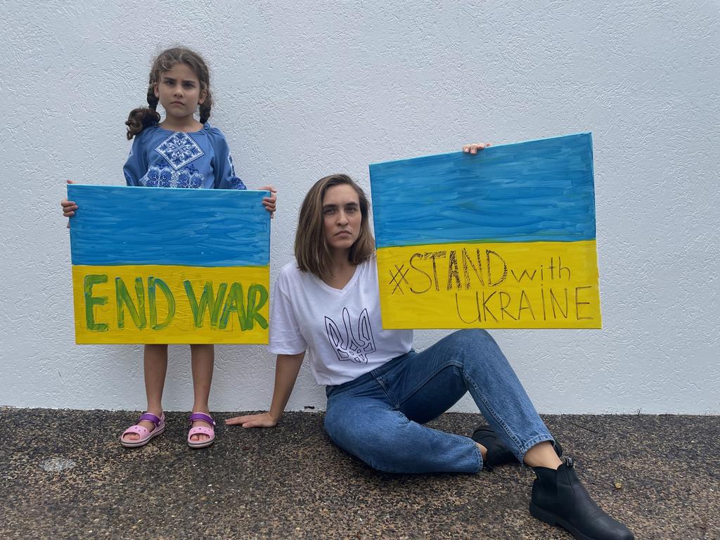 Yuliia Shchedrovska and her daughter Nataliia Taberko holding signs in support of their home country Ukraine. Picture: Supplied.