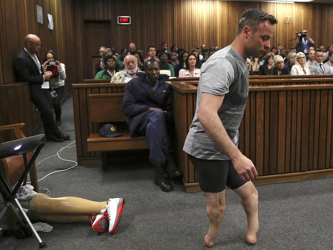 Oscar Pistorius' prosthetics lay on the floor as he walks on his amputated legs during argument in mitigation of sentence by his defence attorney Barry Roux. Picture: AP