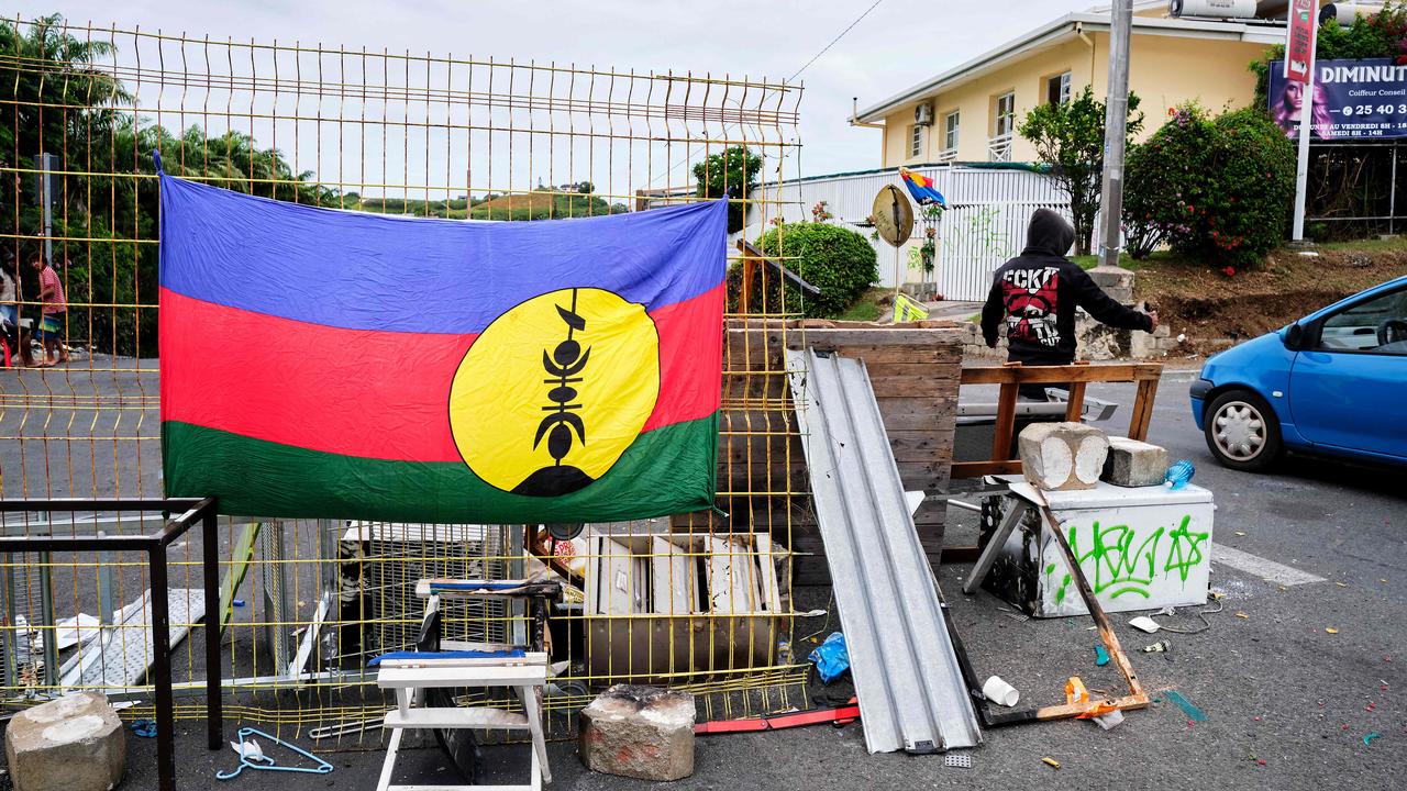 A Kanak flag is displayed at roadblock set up by protesters. Picture: Theo Rouby / AFP