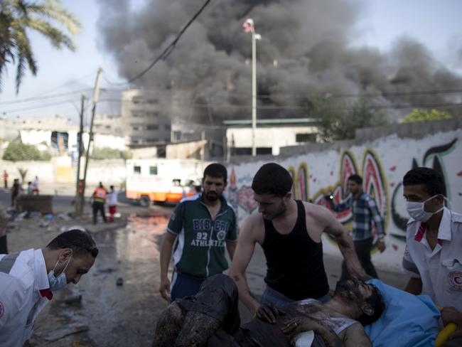 Members of the Red Crescent push a stretcher carrying a wounded Palestinian man following an Israeli air strike on a market place in the Shejaiya neighbourhood near Gaza City. Picture: Marco Longari