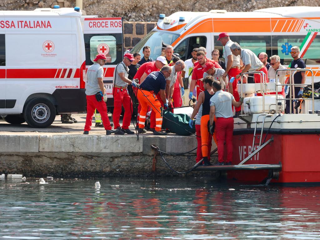 Local authorities made the grim admission they believe the missing passengers are “still inside the boat”. Firefighters are seen above with a bodybag after one person was confirmed dead early in the search. Picture: Igor Petyx / ANSA/ AFP