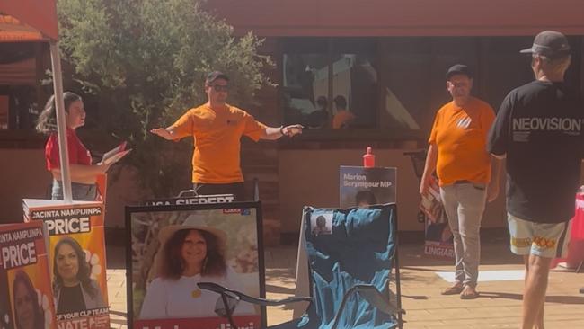 Interstate volunteers for the CLP and a Labor volunteer try to convince an undecided voter heading to the federal election polling booth inside the Alice Springs Town Council building, May 3, 2025. Picture: Gera Kazakov