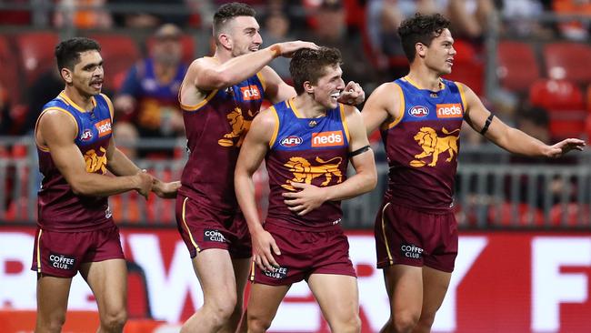 The Lions get around Zac Bailey after a goal. Picture: AAP