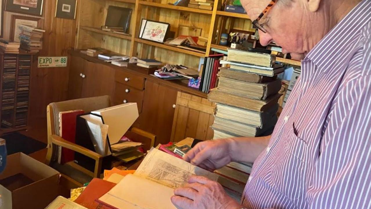 Rob Schwarten looks over a book by Rockhampton author J H Wood.