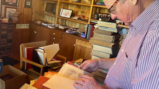 Rob Schwarten looks over a book by Rockhampton author J H Wood.
