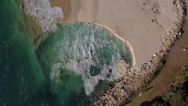 People on the beach at Amity look at the sinkhole as the tide goes out. Picture: Chris Polson