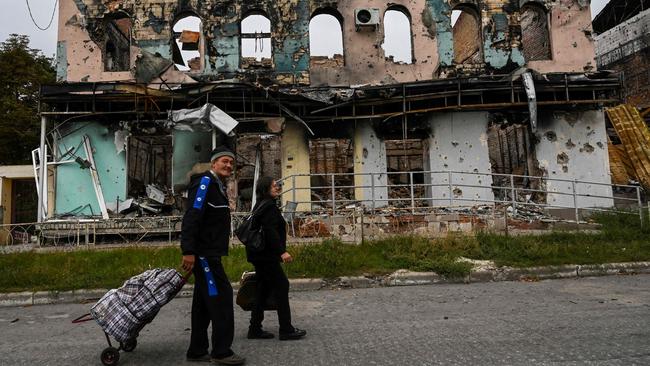 A couple walks past a destroyed building in Izyum, in the Kharkiv region, where Ukraine forces are reclaiming territory. Picture: AFP