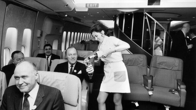 A Pan American air hostess serving champagne in the first class cabin of a Boeing 747 jumbo jet. Picture: Getty