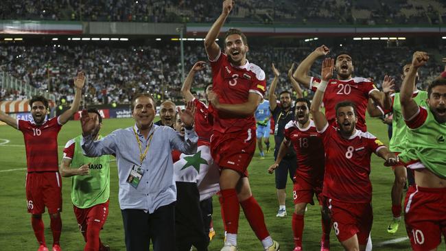 Syria's national soccer team celebrates at the conclusion of their match with Iran.