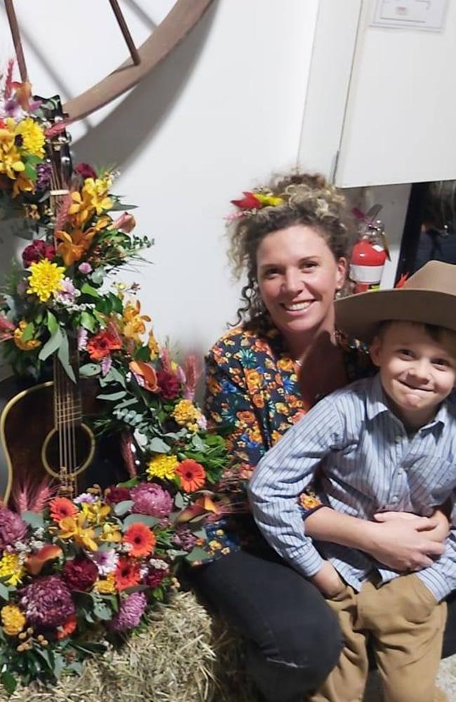 Cass Hourigan adorned a guitar with flowers, for her final presentation at the Flower School. Picture taken with her son, Jonty.