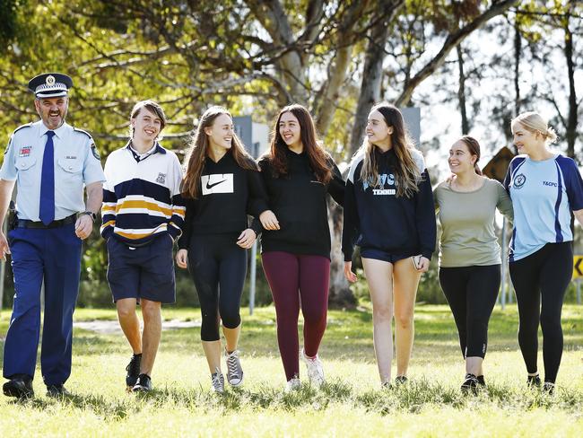 Teens at the Lake Illawarra PCYC are getting involved in some activities put on by the police. Chief Inspector Paul Allman (left) and Senior Constable Jane Keating with local kids. Picture: Sam Ruttyn