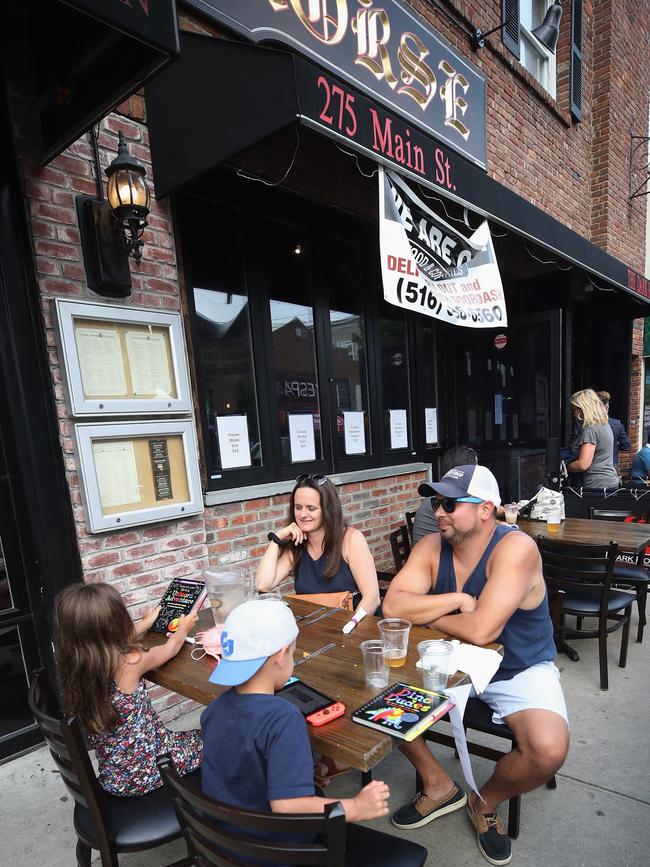 The Fuentes family of North Massapequa dine at outdoor seating on Main Street in Farmingdale, New York. Picture: Getty Images/AFP