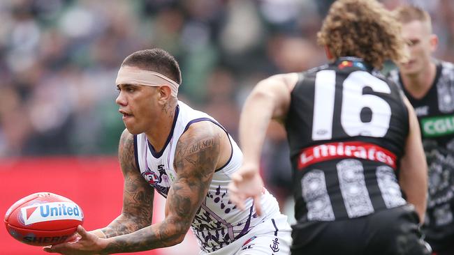 Michael Walters handballs as Pie Chris Mayne moves in to tackle. Pic: Getty Images