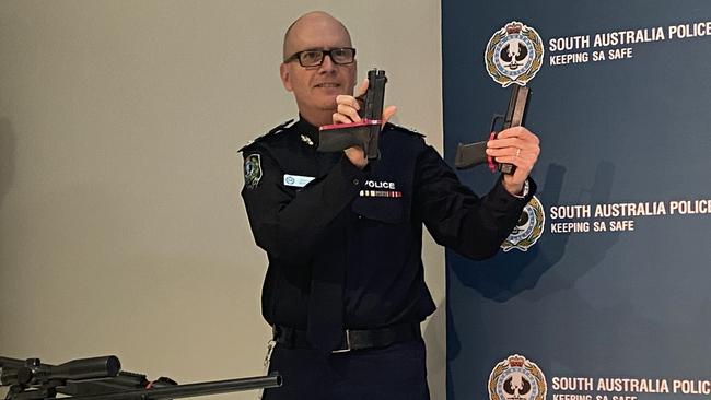 Superintendent Stephen Howard holding a real gun and a gel blaster.