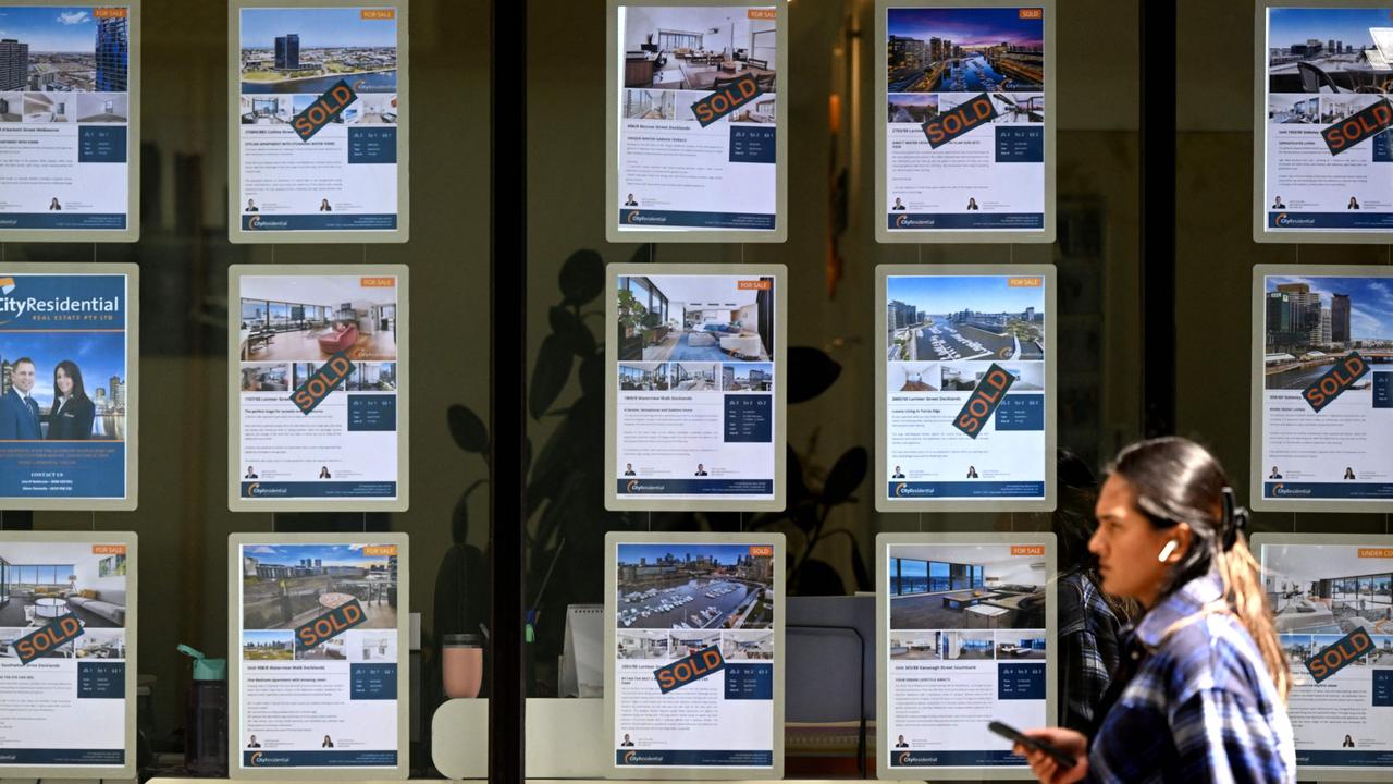 People walk past a real estate agent's window in Melbourne. Photo: William West.