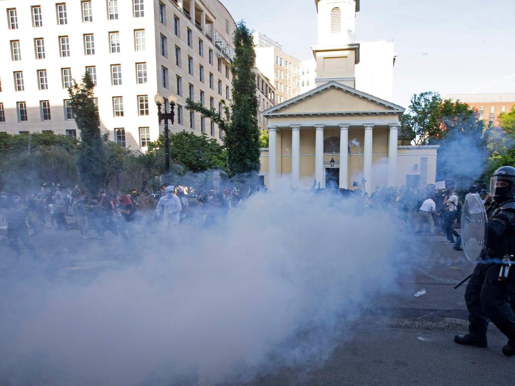 Police officers wearing riot gear push back demonstrators shooting tear gas next to St. John's Episcopal Church outside of the White House. Picture: AFP