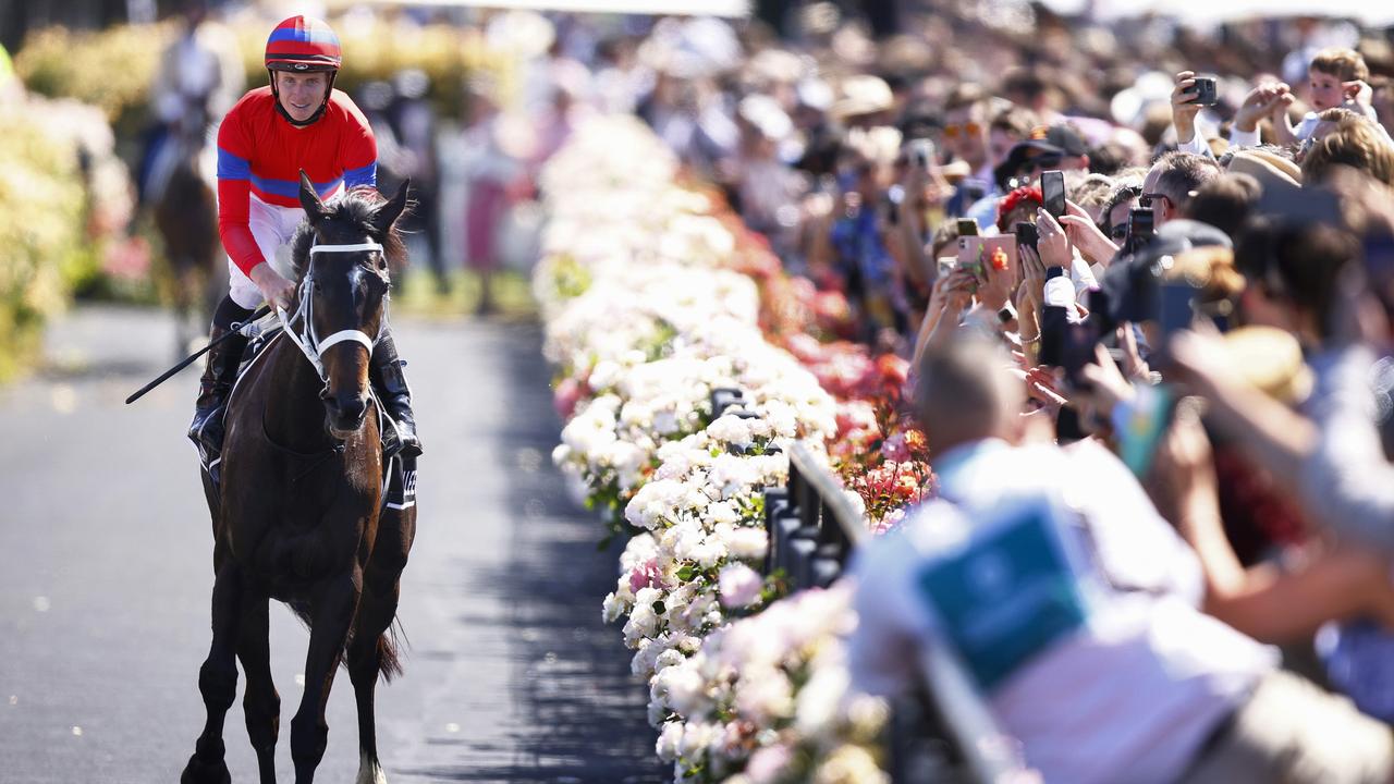 Jockey James Mcdonald and horse Verry Elleegant celebrate after winning the Melbourne Cup on November 2, as the restricted crowd watches on at Flemington Racecourse. Picture: Getty Images