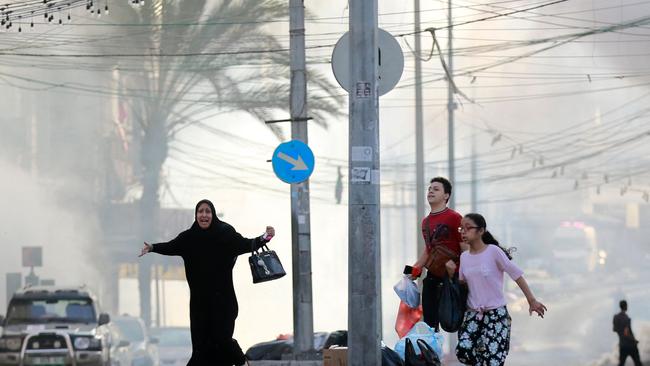 Palestinians run for cover after a strike near the Al-Shifa hospital in Gaza City. Picture: AFP