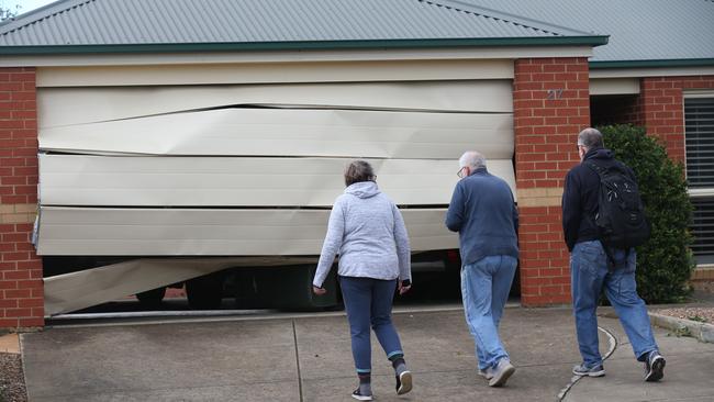 A garage door buckled during the storm. Picture: David Crosling