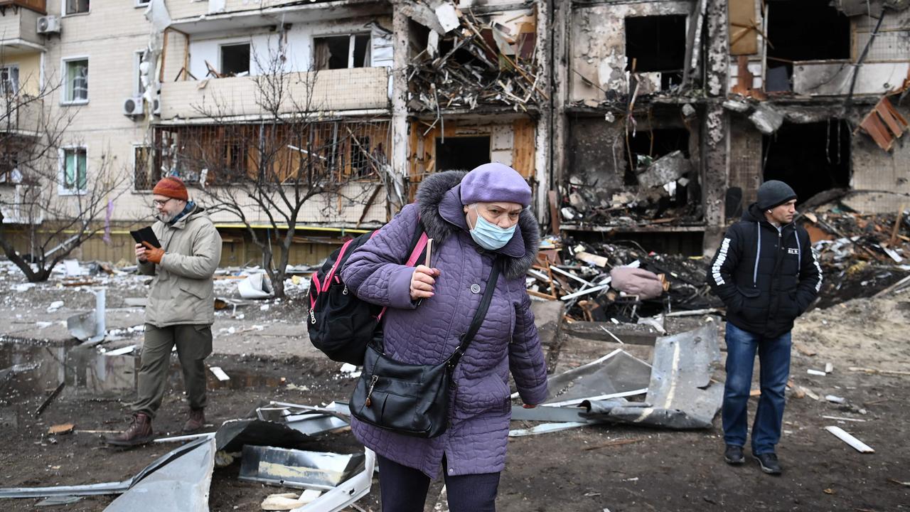 A woman with a backpack walks in front of a damaged residential building at Koshytsa Street, a suburb of the Ukrainian capital Kyiv. Picture: Daniel Leal / AFP