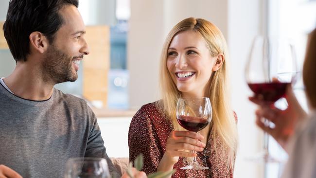 Portrait of a happy friends reunion. Young couples enjoying wine and drinks. Couple enjoying lunch with family at home.