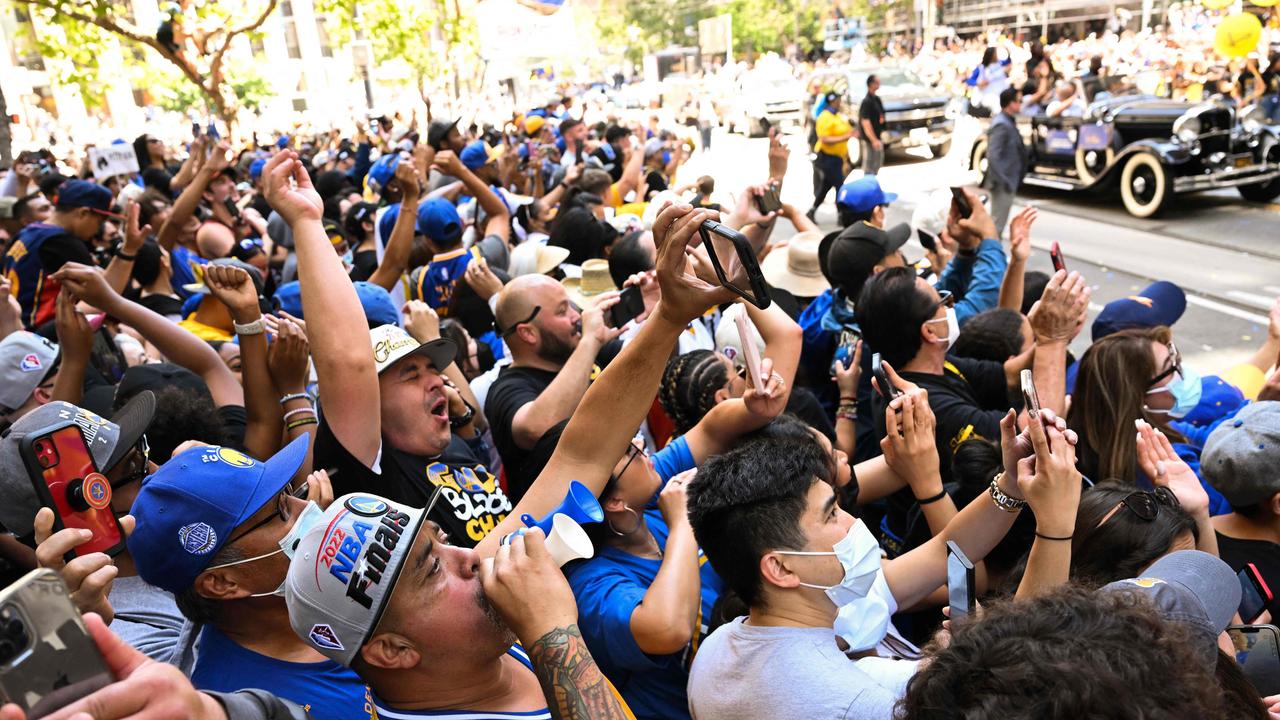 Basketball fans cheer during the Golden State Warriors NBA Championship victory parade. Photo by Patrick T. FALLON / AFP.