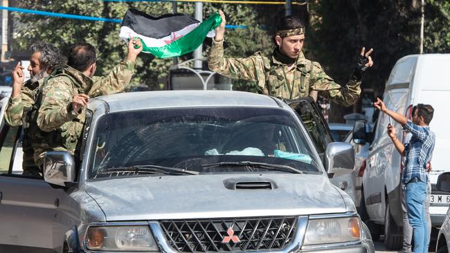 Members of the Turkish-backed Free Syrian Army drive to the Turkey-Syria border. Picture: Getty Images