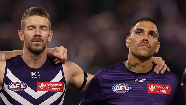 PERTH, AUSTRALIA - MAY 10: Sam Switkoswki, Michael Walters and Michael Frederick of the Dockers line up as the teams pay their respects to former player Cameron McCarthy during the round nine AFL match between Fremantle Dockers and Sydney Swans at Optus Stadium, on May 10, 2024, in Perth, Australia. (Photo by Paul Kane/Getty Images)