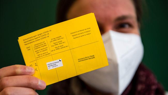 A healthcare worker presents her additional Covid-19 vaccinations card after a vaccination with the AstraZeneca vaccine at the university hospital in Halle/Saale, eastern Germany. Picture: AFP