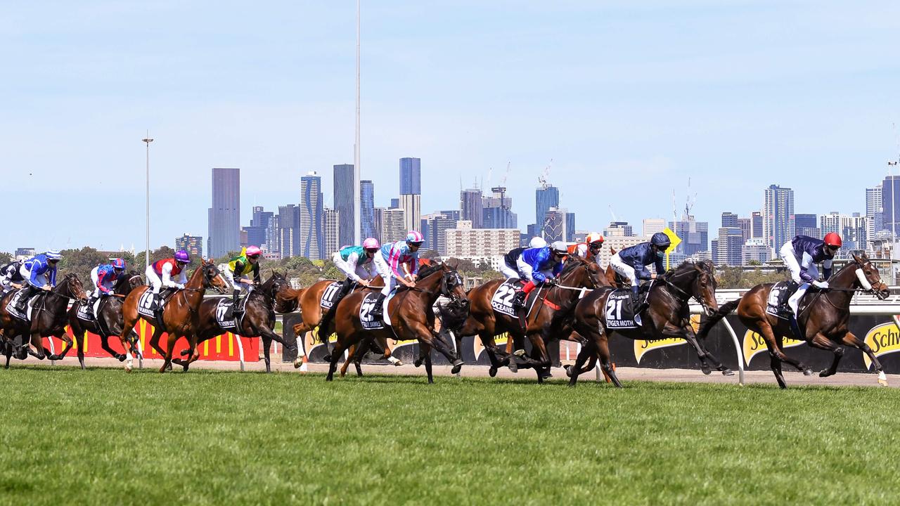 Twilight Payment leads the field down the straight and Tiger Moth pushes forward from his wide barrier. Picture: AFP