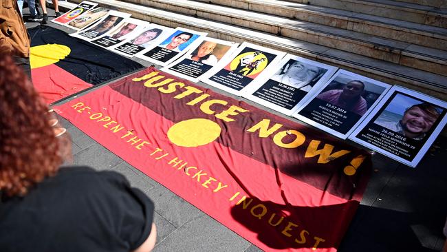 An indigenous flag in front of signs of First Nations people who have died in custody is seen during a Black Death in Custody Rally. Picture: NCA NewsWire/Bianca De Marchi