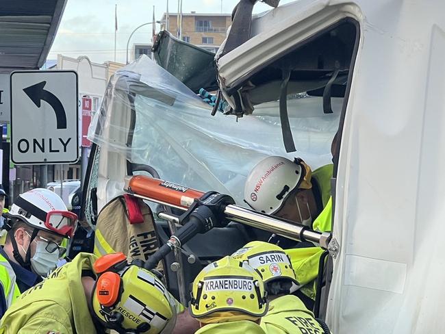 Fire and Rescue NSW worked to free a man trapped in a garbage truck at Lidcombe