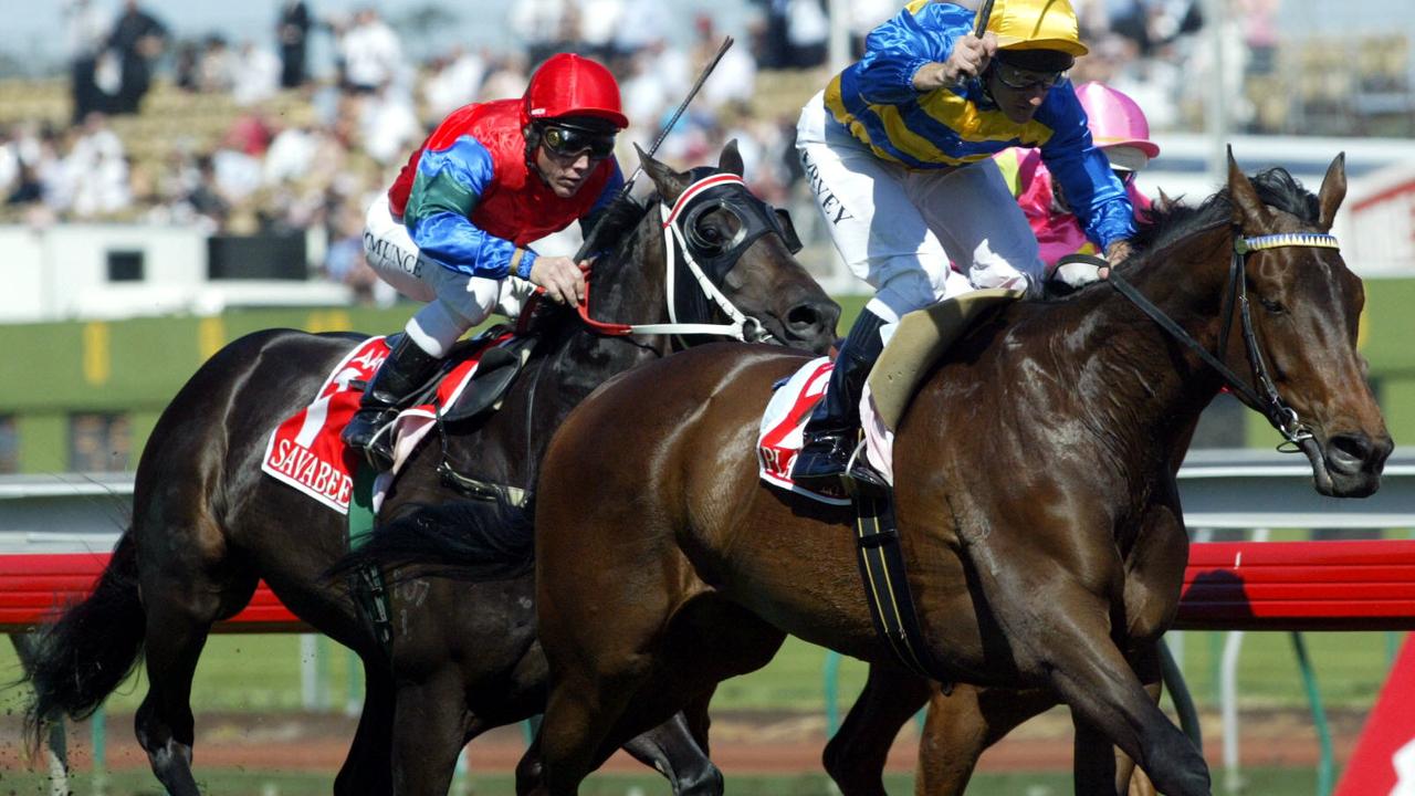 Oct 2004: Jockey Chris Munce (/red /cap) on Savabeel coming from behind, Paul Harvey (L) stands in the stirrups on Plastered as he wins the 2004 Victoria Derby at Flemington. sport horseracing action