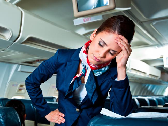 Young air stewardess suffering from headache on an airplane.