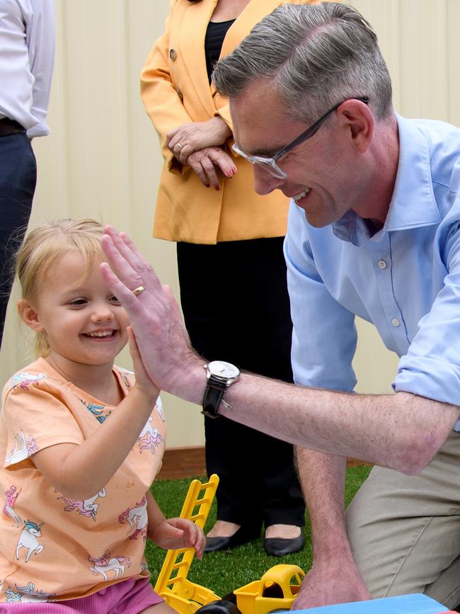 Mr Perrottet high-fives Dakota Brisbane, 3, at a Narellan childcare centre. Picture: AAP