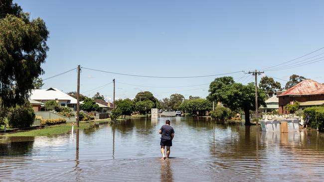 A resident walks through a flooded street in Rochester. Picture: Getty Images