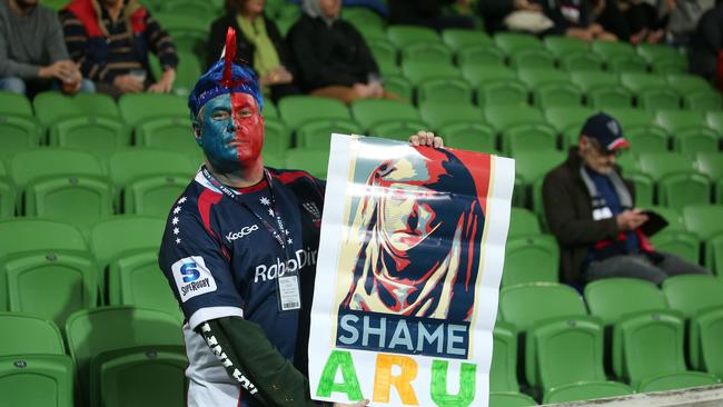 A Rebels supporter in the crowd holds a sign which reads ‘Shame ARU.’