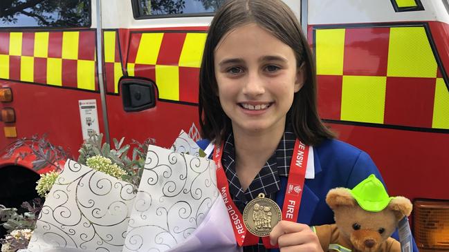 Samantha 'Sammy' Collins, 11, of Narraweena, raised more than $5300 for the Bear Cottage children's hospice at Manly in memory of her best friend Neve Brady who died in 2014. Sammy received a Super Hero Medal from NSW Fire and Rescue for her efforts. Picture: Jim O'Rourke