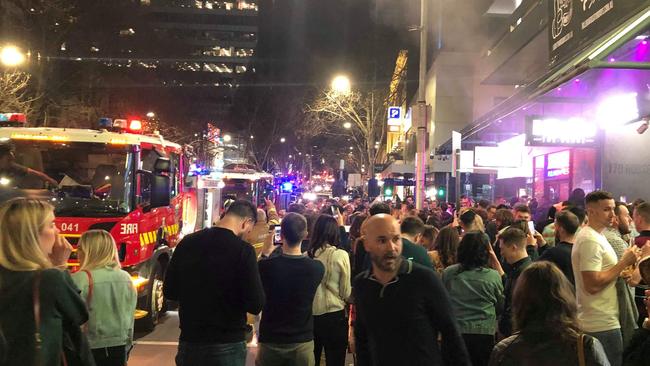 Ticketholders are evacuated from 170 Russell as emergency services arrive.