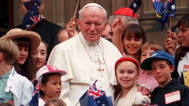 Pope John Paul II surrounded by flag waving schoolchildren on steps of St Mary's Cathedral, 1995.