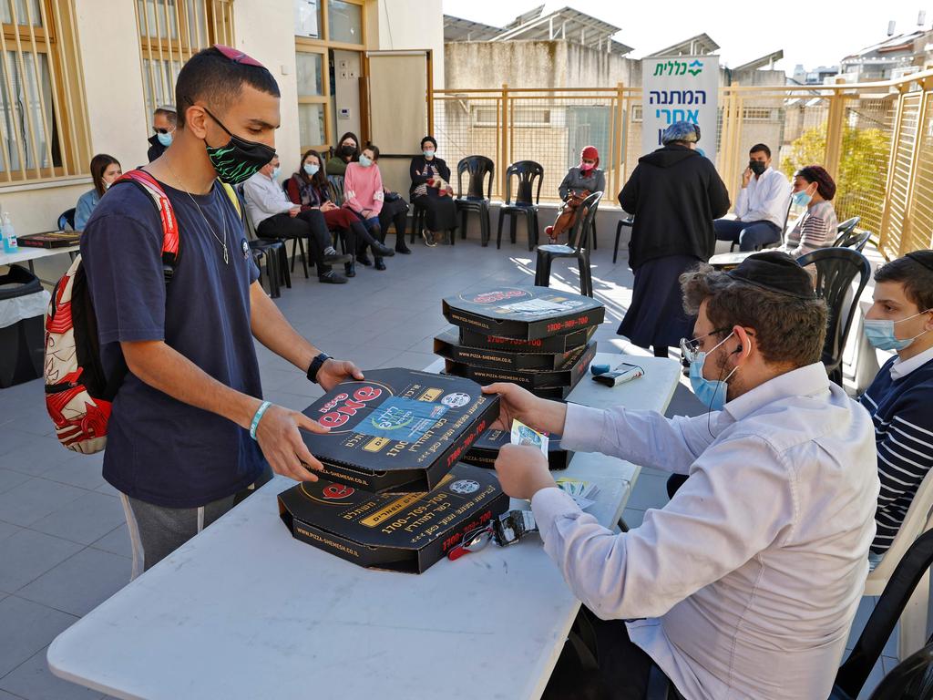 A person receives a pizza after getting a dose of the Pfizer vaccine. Picture: AFP