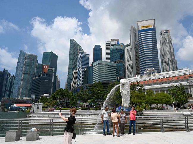 Tourists in front of the Merlion statue in Singapore on March 24, 2022. Picture: Roslan Rahman / AFP.