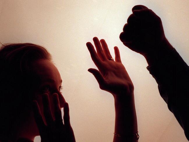 Domestic violence silhouette generic image - fist raised against woman./Violence