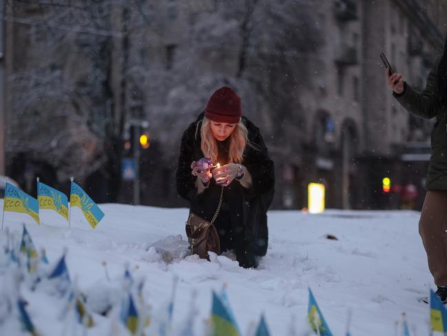 A woman lights a candle in Independence square in Kyiv, Ukraine. Picture: Getty Images.