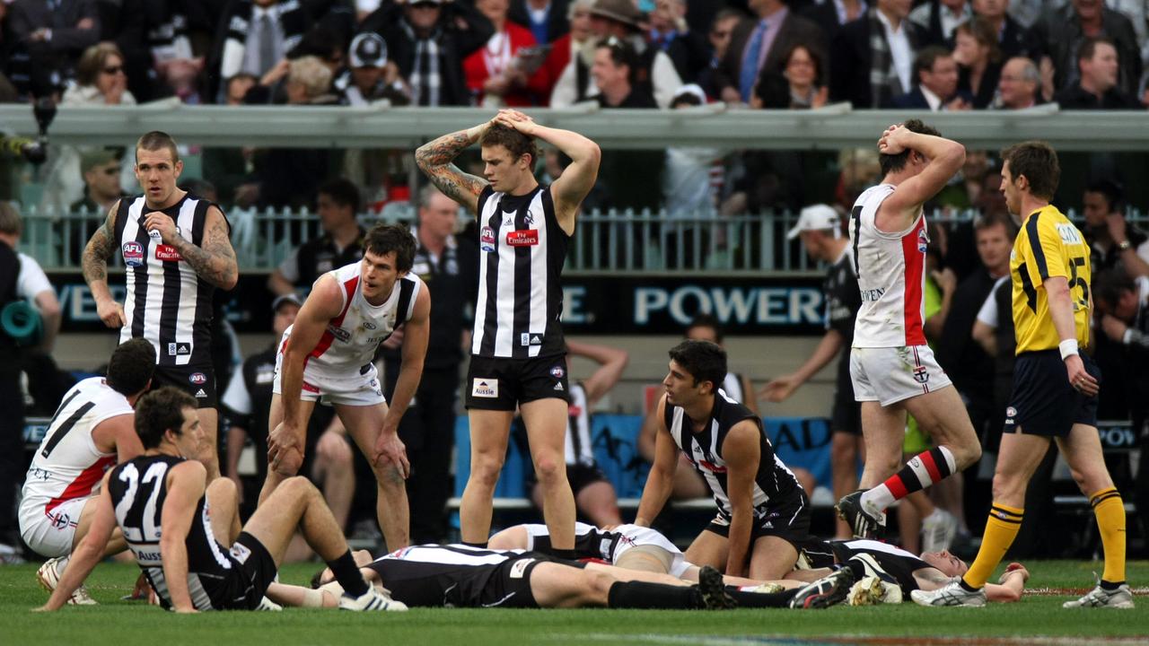 Players lie down after at the end of the drawn Collingwood v St Kilda 2010 AFL Grand Final.