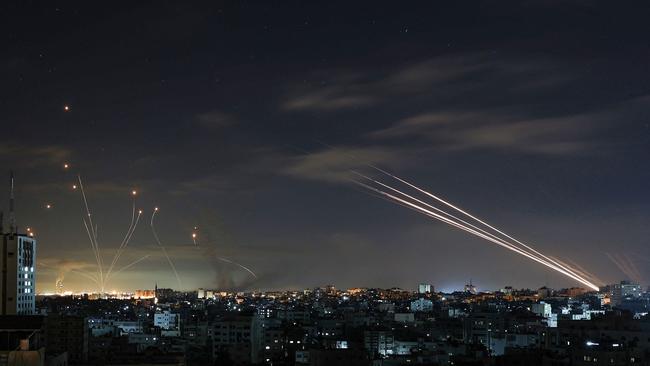 Israel's Iron Dome missile defence system, left, intercepts rockets, right, fired by the Hamas movement from Gaza city. Picture: AFP