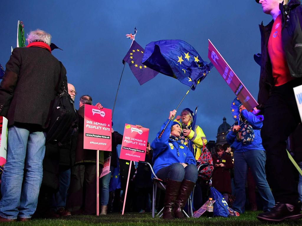 Anti-Brexit activists wave EU flags as they demonstrate with other protesters outside of the Houses of Parliament in central London on January 15, 2019. - Parliament is to finally vote today on whether to support or vote against the agreement struck between Prime Minister Theresa May's government and the European Union. (Photo by Ben STANSALL / AFP)